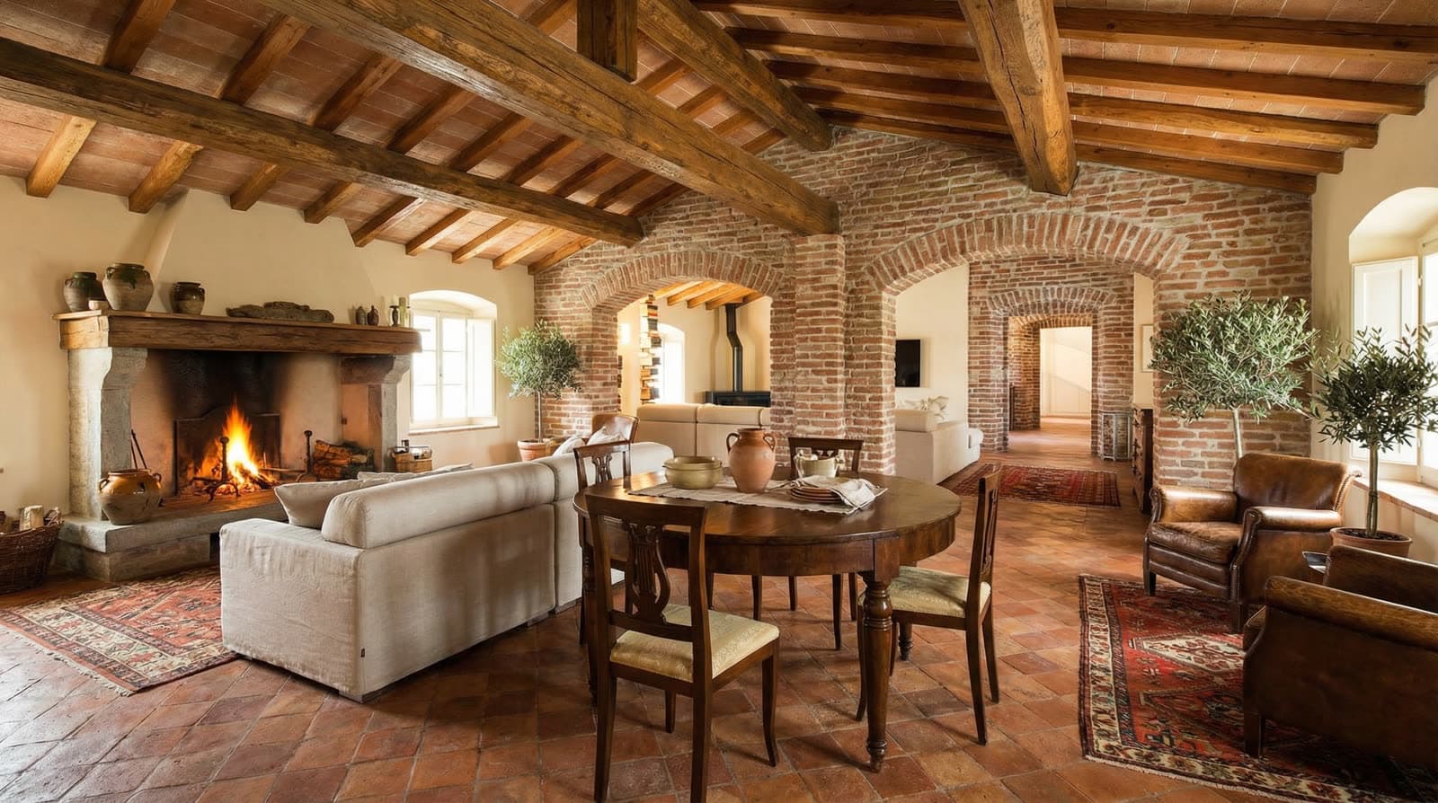 Soggiorno con camino, travi a vista e pavimento in cotto in una casa ristrutturata dallo Studio Spinoni