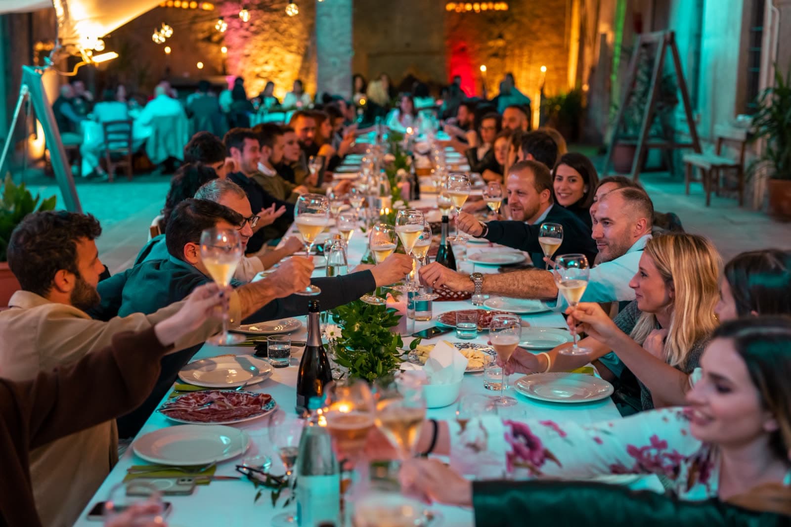Una lunga tavolata all'aperto durante una serata di degustazione in cantina